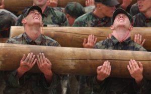 Team of Military Members Carrying Heavy Log Together