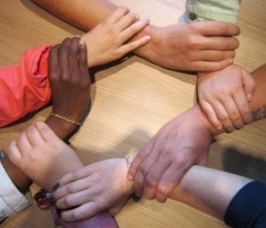 Group of Hands Interlocking Wrists Making a Circle