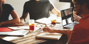 People Sitting at Restaurant Table with Drinks and Computers